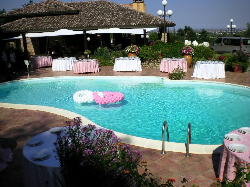 Cuori di palloncini rosa e bianchi che galleggiano nella piscina di un agriturismo, con i tavoli dell'aperitivo apparecchiati sul bordo