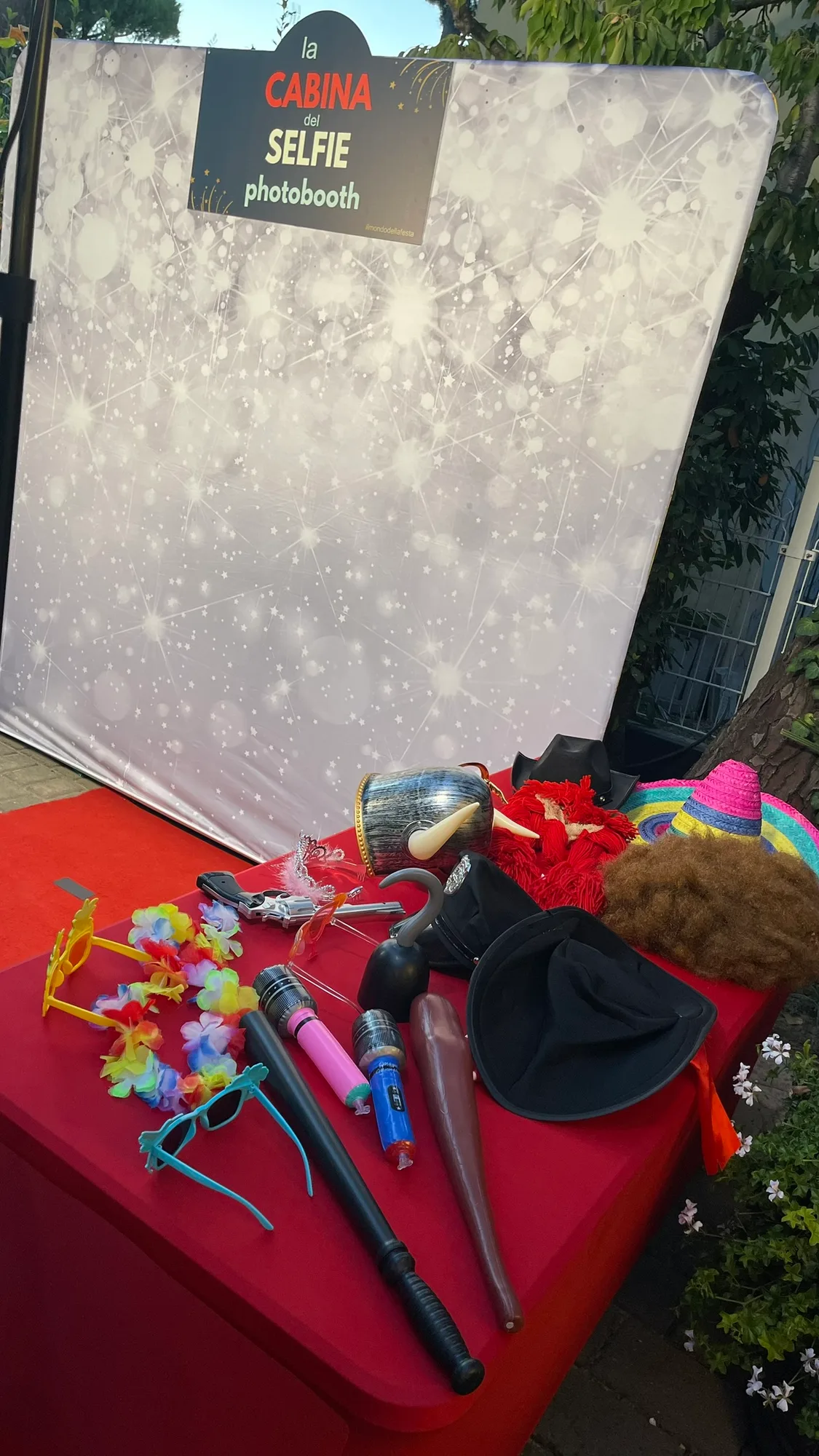 Il fondale scintillante della Cabina del Selfie con il tappeto rosso e il tavolo degli accessori pronto prima dell'arrivo degli invitati
