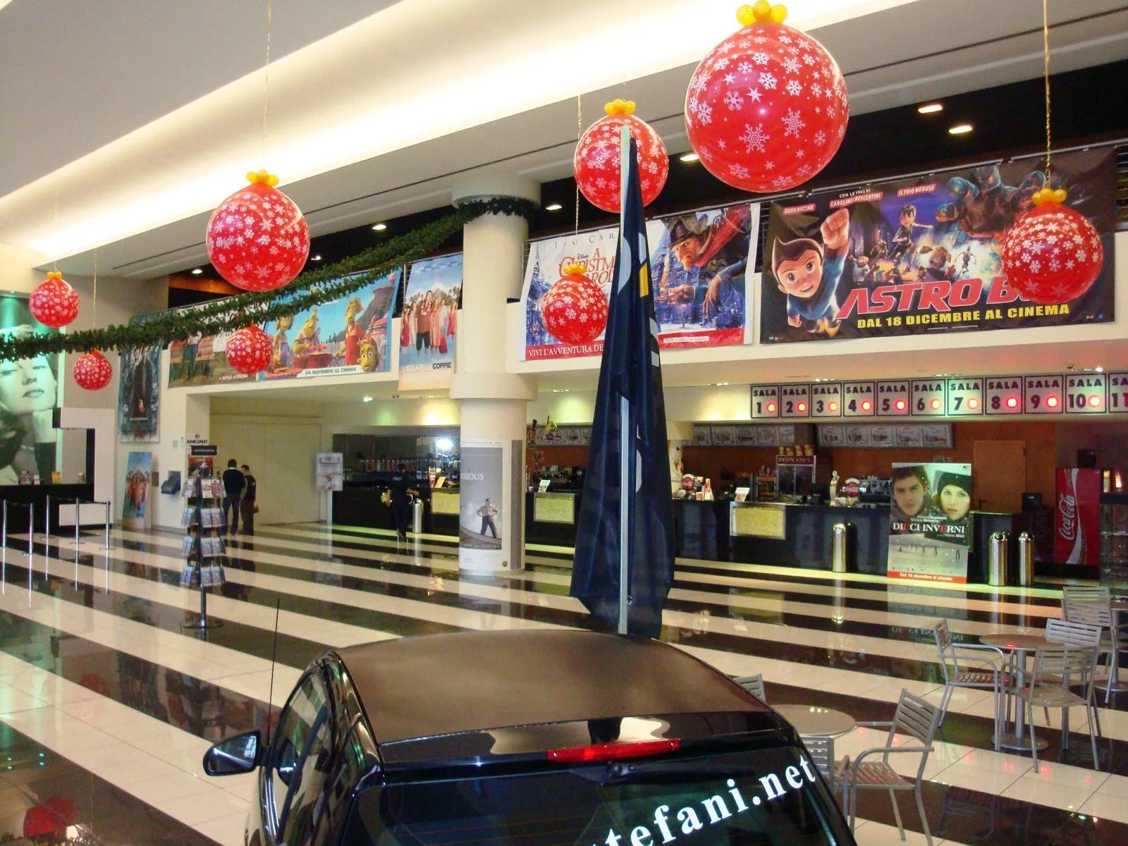 Grandi palline di Natale rosse con i fiocchi di neve bianchi appese nell'atrio di un cinema