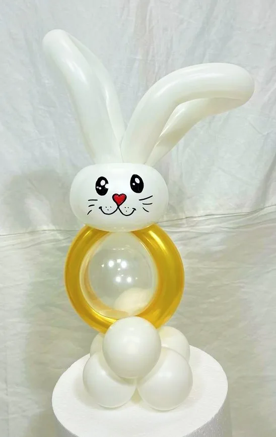 Coniglietto di palloncini bianchi e oro montato su una base tonda, composizione da tavolo