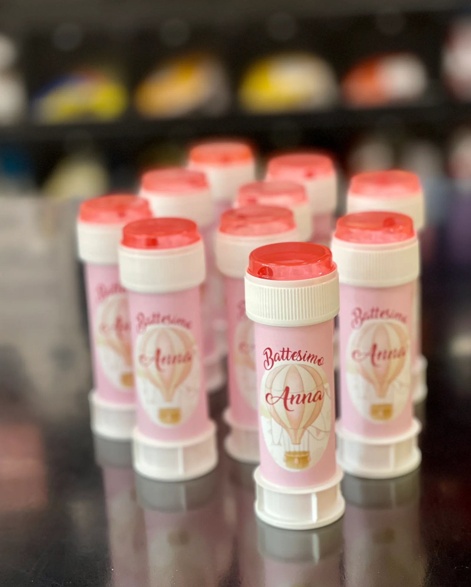 Flaconcini di bolle di sapone con etichette rosa con una mongolfiera e la scritta Battesimo Anna
