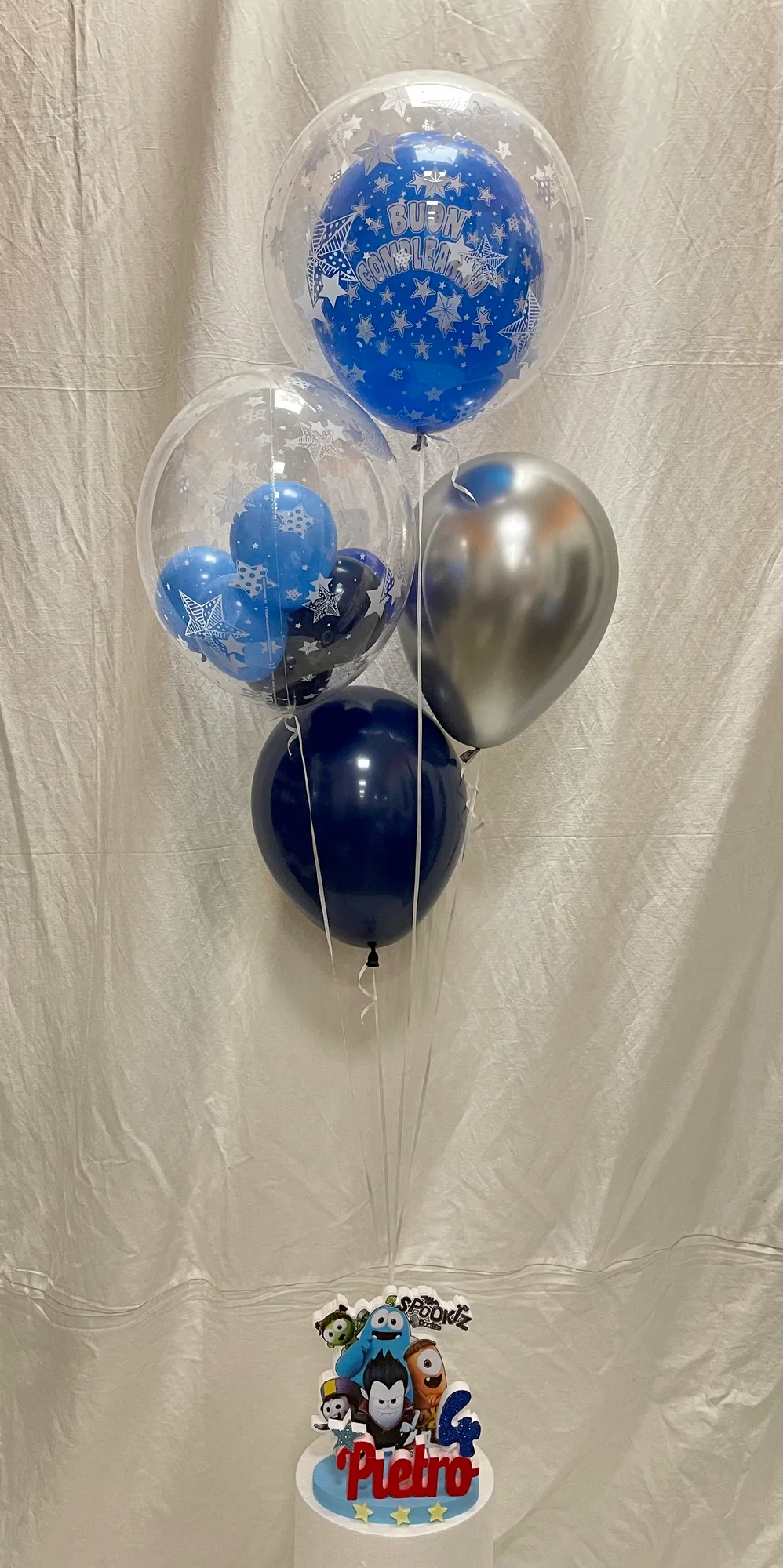 Bouquet di palloncini blu, argento e Buon Compleanno legato alla sagoma in polistirolo con il nome Pietro e il numero 4