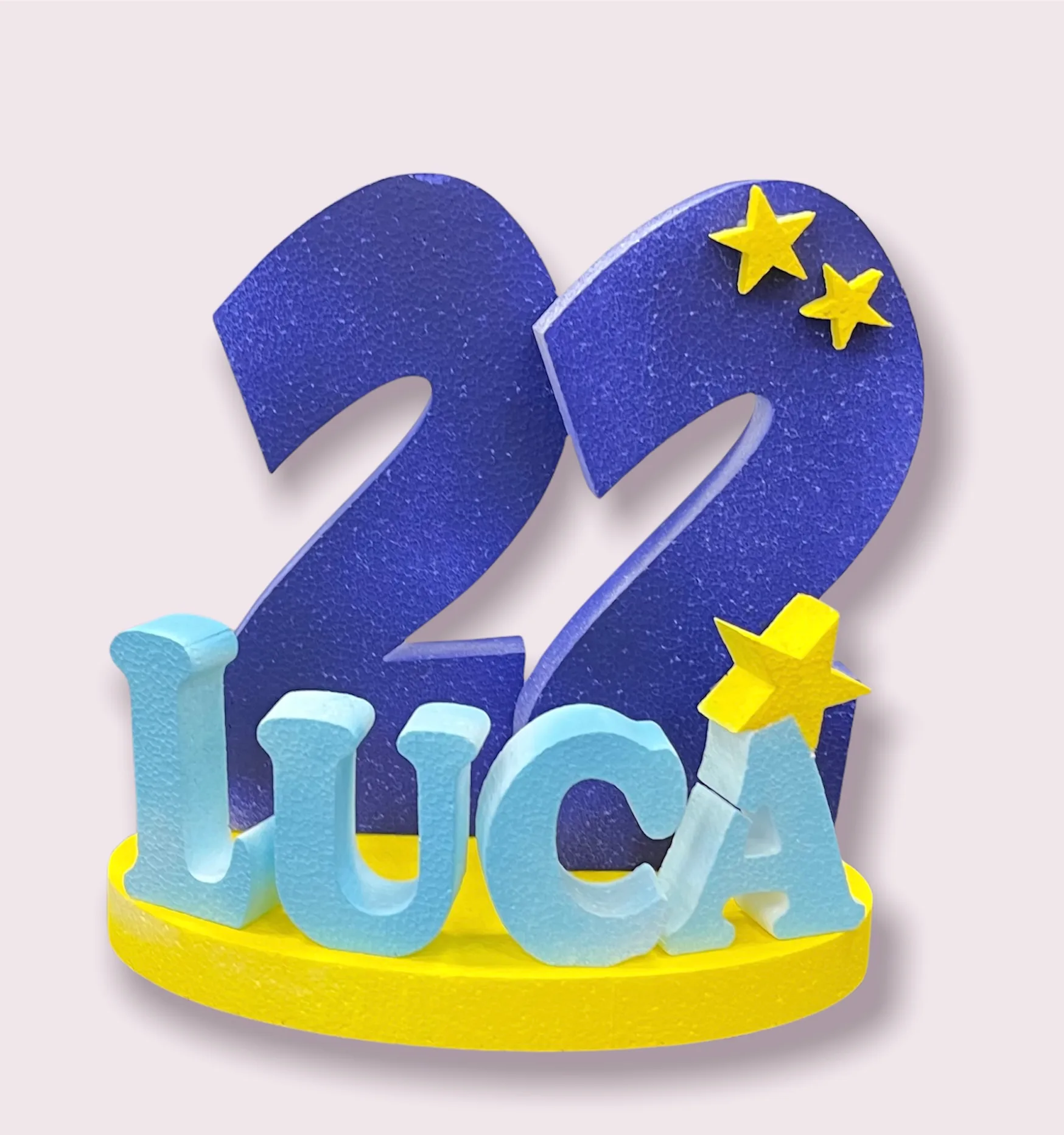 Numero 22 in polistirolo blu con stelle gialle e il nome LUCA in lettere azzurre su una base gialla