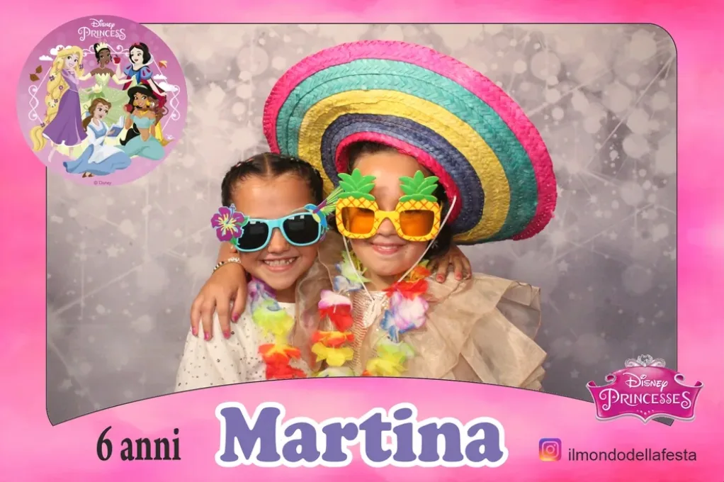 Cornice rosa a tema principesse per i 6 anni di Martina: due bambine in posa con sombrero colorato, occhiali a forma di ananas e collane hawaiane