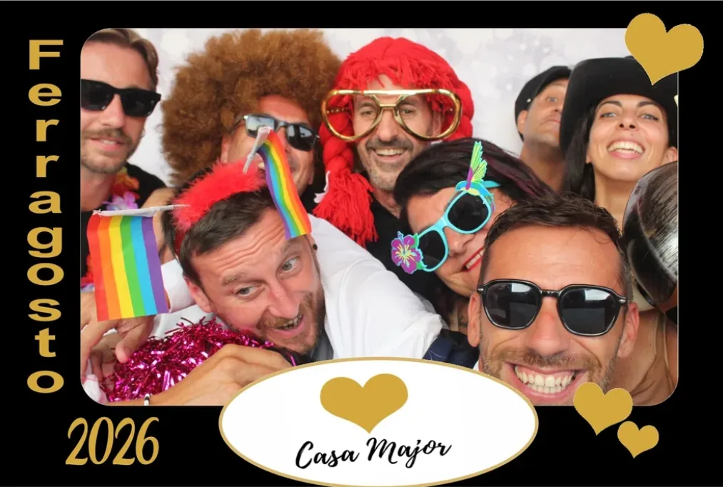 Cornice nera e oro Ferragosto 2026 Casa Major: un gruppo di amici in posa con parrucche, occhiali giganti e bandierine arcobaleno