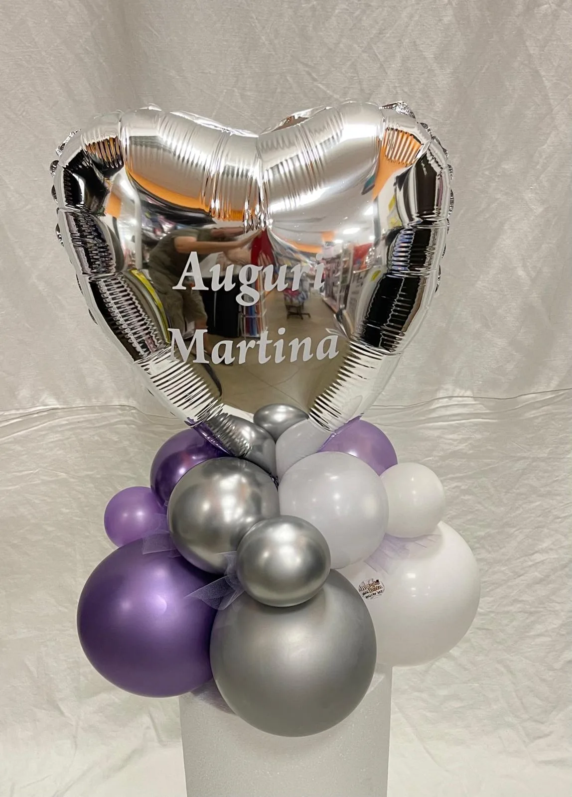 Composizione da tavolo con cuore in mylar argento personalizzato Auguri Martina e base di palloncini viola, argento e bianchi
