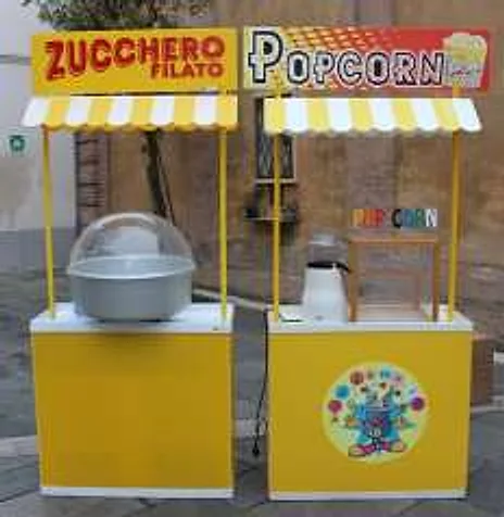 Carrettini gialli e bianchi dello zucchero filato e dei popcorn montati in piazza